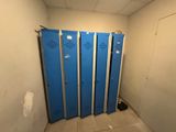 several blue lockers are lined up in a room with tile flooring