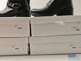 a pair of black boots sitting on top of boxes
