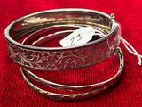 trois bracelets en argent sur un tissu rouge avec une étiquette de prix