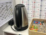 a coffee pot on a shelf next to a calendar