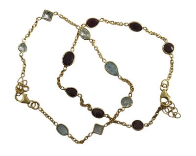 un gros plan sur un bracelet à chaîne en or orné de pierres bleues et vertes