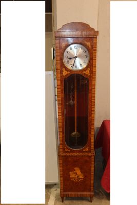 une horloge de parquet qui se trouve dans un coin de la pièce