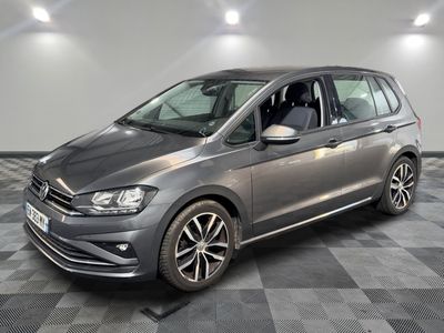 une Volkswagen Touran grise garée sur un sol à damier