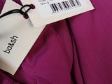 the label on the back of a purple dress