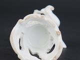 a white vase that is sitting on a black surface