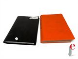 an orange and black book sitting next to each other on a white surface