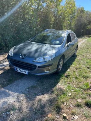 the car is parked on the side of the road near the trees