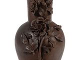 un vase marron orné de fleurs sur fond blanc