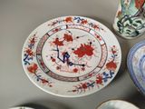 many plates and cups on a table with a clock on them