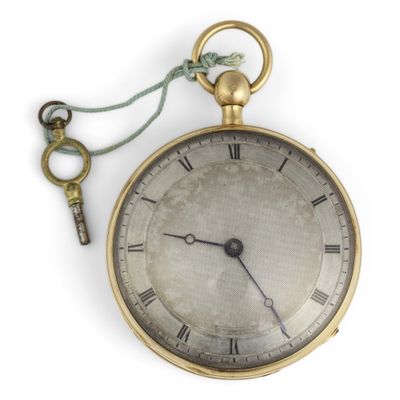 a gold pocket watch with a key attached to it