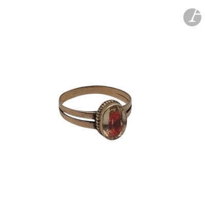 Gros plan sur une bague ornée d'une pierre rouge