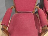 pair of red upholstered chairs in a room with wood flooring
