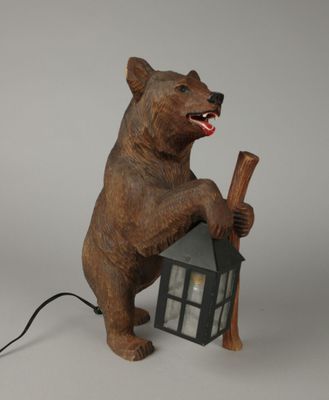 statue d'un ours tenant une batte de baseball et une maison