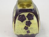 a yellow vase with a black design on it