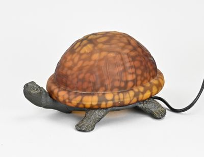 une petite tortue assise sur une table