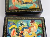 two boxes with paintings on them sitting on a table