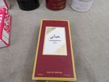 a box of perfume sitting on a table next to other bottles of perfume