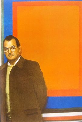 tableau représentant un homme debout devant un tableau aux couleurs orange, bleu et rouge