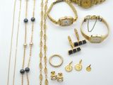 a group of gold and silver jewelry including a watch, bracelets, and rings