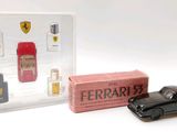 a small toy car next to a box of perfumes