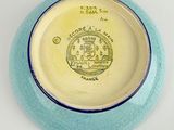 a blue and yellow plate with a picture of a castle on it