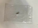 a small screw in a plastic bag on a table