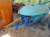 a blue tractor with a yellow hose attached to it