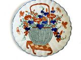 une assiette décorative sur laquelle est représenté un panier de fleurs