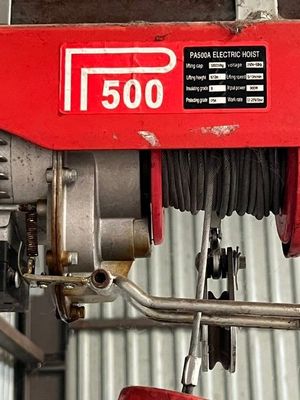 une photo d'un palan électrique rouge dans un garage