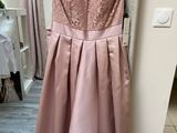 the back of a dress hanging on a hanger in front of a mirror