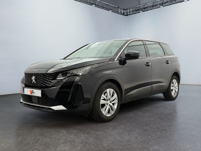 un SUV gris garé dans une grande pièce au sol noir