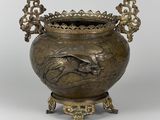 un vase en bronze richement décoré, orné d'un oiseau