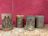 plusieurs types de vases sculptés posés sur une table, sur fond rouge