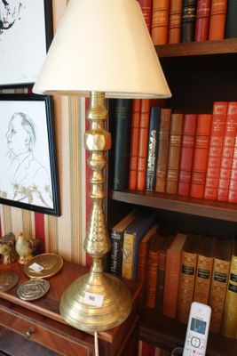 une lampe posée sur une table devant une bibliothèque
