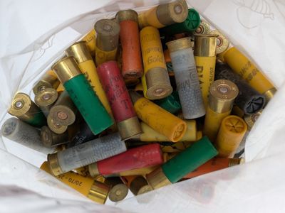 un sac blanc rempli de cartouches de fusil de chasse posé sur une table