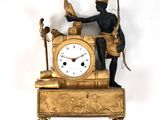 une horloge en or surmontée d'un homme tenant un oiseau dans ses mains