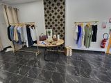 an image of a clothing store with clothes on racks