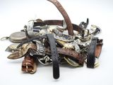 une pile de montres de différents modèles posées sur une surface blanche