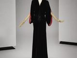 une photo d'un mannequin vêtu d'une robe noire et d'une cape rouge