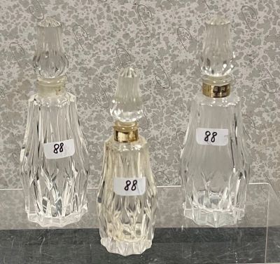 trois bouteilles en verre portant des numéros, posées sur une table