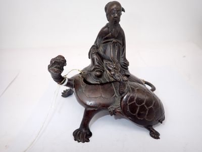 statue en bronze représentant une femme chevauchant une tortue sur le dos de laquelle se trouve un oiseau