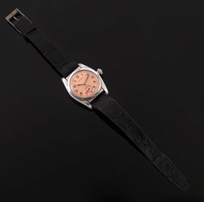 a close up of a watch on a black surface with a black background