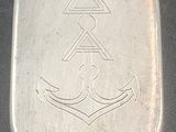 a small silver box with a silver anchor on it
