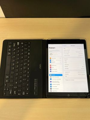 une tablette et un ordinateur portable posés sur un bureau, avec un clavier