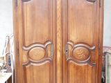 une grande armoire en bois dans une pièce où se trouvent de nombreux meubles