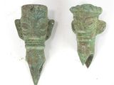 paire de sculptures anciennes représentant des têtes en bronze sur fond blanc
