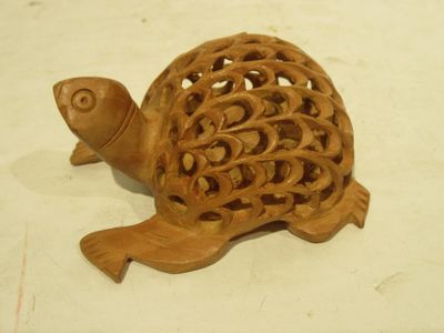 a wooden turtle that is sitting on a table