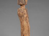 a wooden statue of a person with a head on a stand