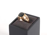 une image représentant une bague en or sertie d'une pierre noire