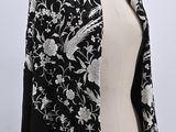 a black and white shawl with white flowers on it